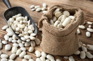 Ahşap bir masa üzerinde Jüt çuval içinde fasulye.