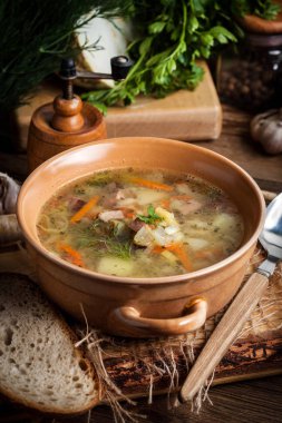 Bezelye çorbası ile sebze ve ahşap bir masa pastırma. Karanlık ışık.