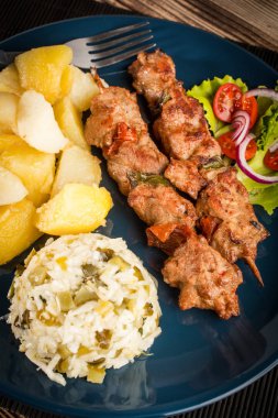 Şiş kebap - ızgara et, kızarmış patates ve sebze.