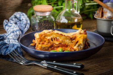 Kırmızı şarap ile lezzetli sıcak lazanya parçası. Küçük alan derinliği.