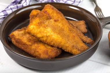 Kırıntıları bir seramik tava üzerinde cod parçaları.