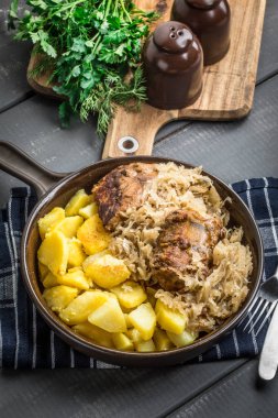 Kızarmış patatesle servis edilen lahana turşulu pirzola..