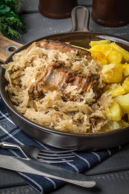 Kızarmış patatesle servis edilen lahana turşulu pirzola..