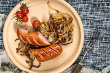 Onionson bir tabak kızarmış sosis. Üstten görünüm.