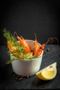 Taş plaka üzerinde kupada karides. Seçici odak. Karanlık ışık.