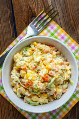 Patates, mısır, havuç, yumurta ve mayonezli salata. Sığ alan derinliği.