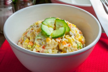 Patates, mısır, havuç, yumurta ve mayonezli salata. Sığ alan derinliği.