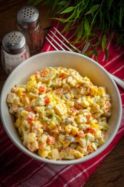 Patates, mısır, havuç, yumurta ve mayonezli salata. Sığ alan derinliği.