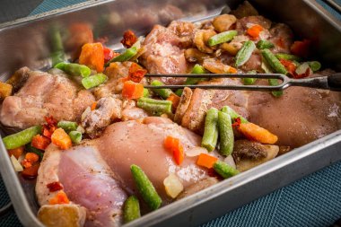 Bir kavurma tavada sebzeli tavuk eti pişirme için hazırlanan.