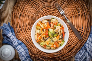 Kızarmış tavuk parçaları ile beyaz bir kase sebze. Üstten Görünüm.