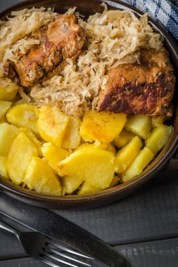 Kızarmış patatesle servis edilen lahana turşulu pirzola..