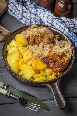 Kızarmış patatesle servis edilen lahana turşulu pirzola..