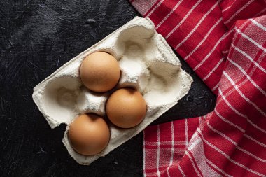 Ahşap rustik arka plan üzerinde taze çiftlik yumurtaları. Karanlık ışık.