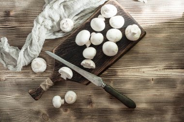 Ahşap Doğrama tahtası üzerinde taze çiğ mantar. Üstten görünüm.