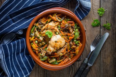 Kızarmış tavuk parçaları siyah plaka sebze ile.