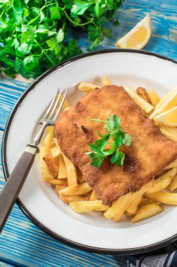 Tabağında patates kızartması olan kızarmış morina balığı..