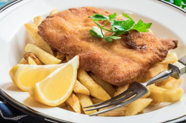 Tabağında patates kızartması olan kızarmış morina balığı..