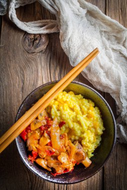 Ahşap tab tavuk ve sebze parçaları ile safran pirinç