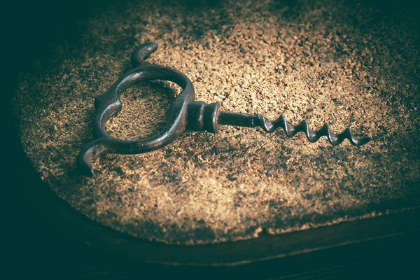 An old corkscrew on a cork background. — Stock Photo, Image