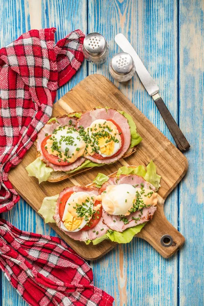 Sandwich with tomatoes, eggs and lettuce.