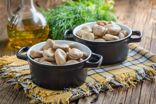 Saubohnen in schwarzen Schalen serviert. — Stockfoto