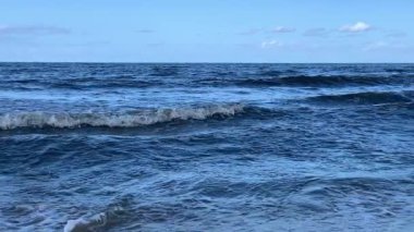 Mavi dalgalar yavaş çekimde sahil i içine rulo.