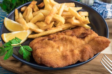 Tabağında patates kızartması olan kızarmış morina balığı..