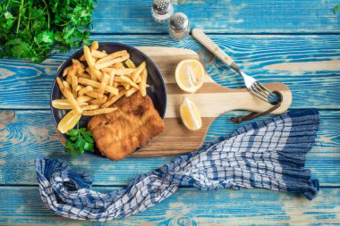 Tabağında patates kızartması olan kızarmış morina balığı..