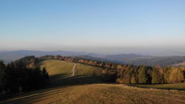 Batan güneşin ışığında sonbahar dağlarının üzerinden uçmak. Beskid Dağları, Polonya, Slovakya. Görkemli manzara. 