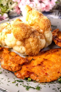 Haşlanmış karnabaharla servis edilen marine edilmiş tavuk göğsü..