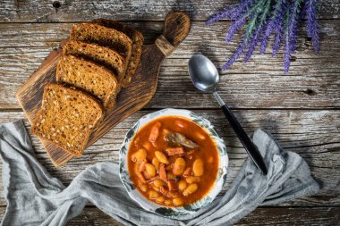 Domates soslu fasulye, pastırma ve sosis. Seçici odak.