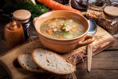 Bezelye çorbası ile sebze ve ahşap bir masa pastırma. Karanlık ışık.