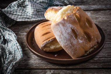 Tahta masada peynirli çörekler. Küçük bir alan derinliği. Koyu ışık.