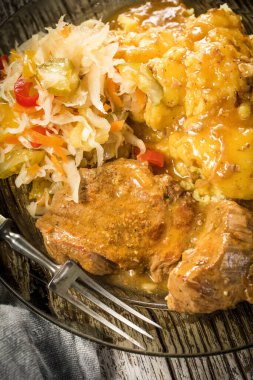 Kendi soslu haşlanmış domuz eti haşlanmış patates ve salatayla servis edilir. Sığ alan derinliği.