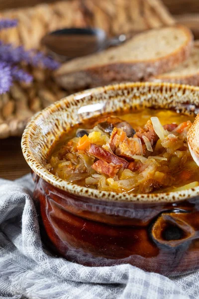 Traditional russian sour cabbage soup on wooden table. Selective focus.