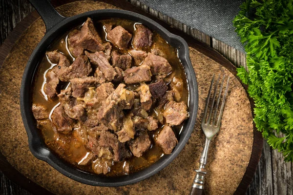 Guisado Carne Uma Frigideira Ferro Fundido Fundo Madeira Profundidade Campo — Fotografia de Stock