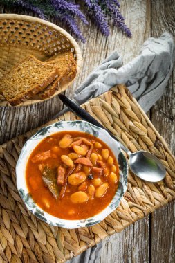 Domates soslu fasulye, pastırma ve sosis. Seçici odak.