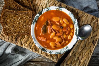 Domates soslu fasulye, pastırma ve sosis. Seçici odak.