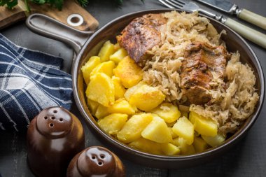 Kızarmış patatesle servis edilen lahana turşulu pirzola..