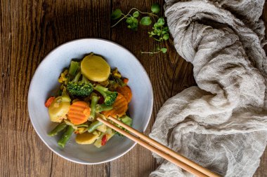 Ahşap masa üzerinde seramik kase sebze komposto.