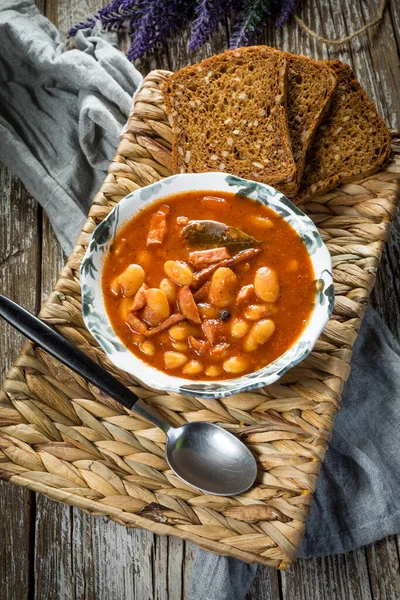 Domates soslu fasulye, pastırma ve sosis. Seçici odak.