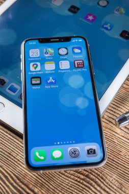 KATOWICE, POLAND - 23 Şubat 2020: Ipad Air 2 ve Ipone XS ahşap arka planda.