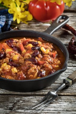 Ahşap arka planda kızartma tavasında Chili con carne. Seçici odak.