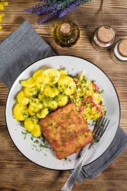 Akşam yemeğinde patates ve lahana turşusu salatası ile haşlanmış balık. Seçici odak.