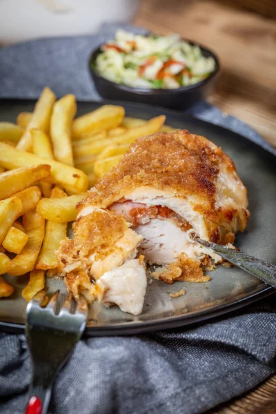 Pastırma ve peynirle doldurulmuş kızarmış tavuk göğsü patates kızartması ve salata ile servis edilir. Küçük alan derinliği.