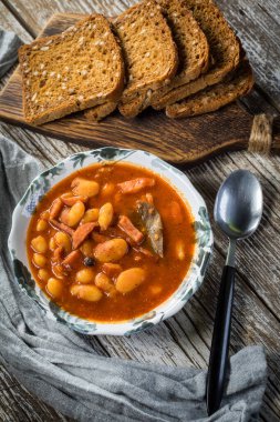 Domates soslu fasulye, pastırma ve sosis. Seçici odak.