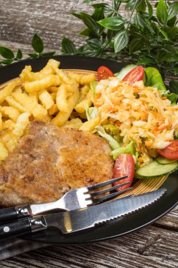 Geleneksel Polonya yemeği: kızarmış domuz pirzolası, patates kızartması ve salata ile servis edilir.. 