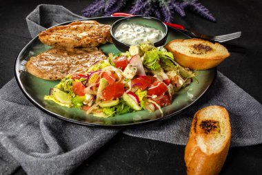 Izgara tavuk eti ve taze sebze salatası, marul, roka, turp, salatalık ve domates. Koyu ışık..