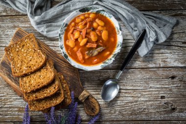 Domates soslu fasulye, pastırma ve sosis. Seçici odak.