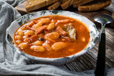 Domates soslu fasulye, pastırma ve sosis. Seçici odak.